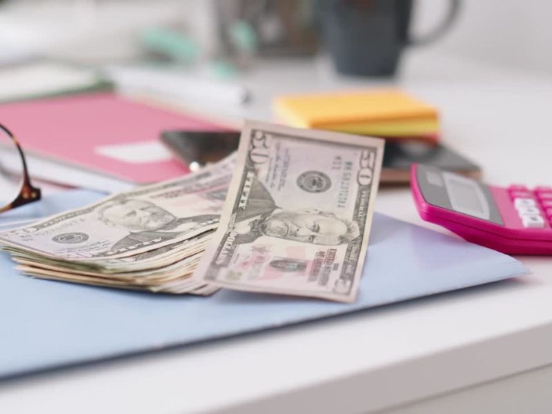 prikaz naočara, novca, kalkulatora na radnom stolu i dokumenata za štednju novca u banci