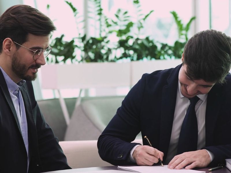 čovek potpisuje papire u banci