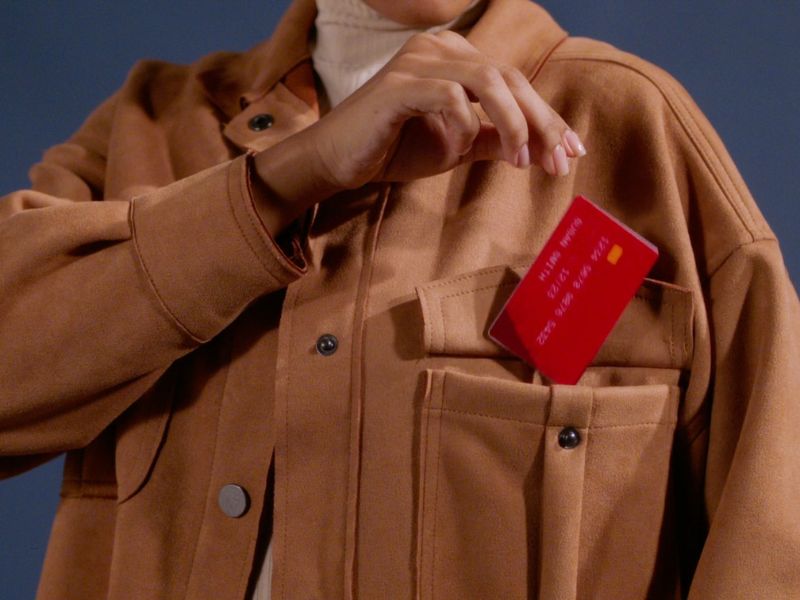 osoba ubacuje karticu u džep na jakni